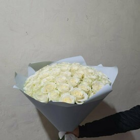 Большой букет белых роз в дизайнерской упаковке