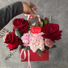 Композиция в сумочке с гортензией и красными розами.