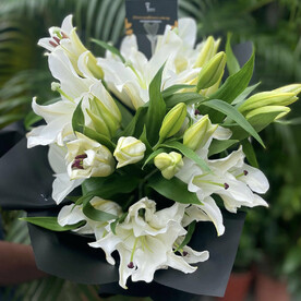 Букет из 9 белых лилий в черной бумаге