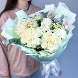 Нежный белый букет из французских роз, кустовой розы, диантусов и орхидей цимбидиум в матовой упаковке