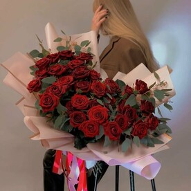 Розы с зеленью в стильной упаковке