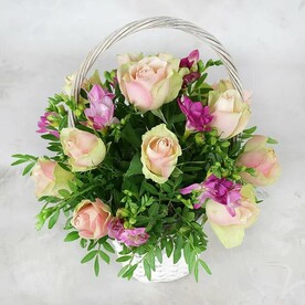 15 зелено-розовых роз, фрезии и листьев фисташки в корзине