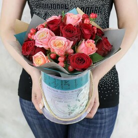 Композиция из красных и розовых роз с гиперикумом в шляпной коробке