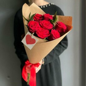 Букет из красных роз с добавлением зелени рускуса в крафтовой упаковке