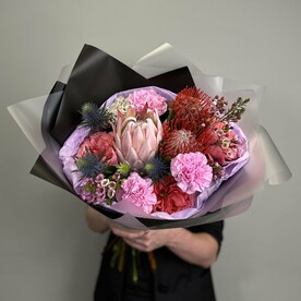 Экзотический букет из королевской розы и пионовидной розы с диантусами и зеленью в стильной упаковке