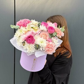 Яркая композиция из стойких цветов в шляпной коробке