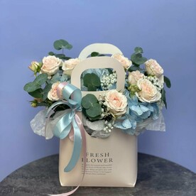 Композиция в сумочке с голубой гортензией и с кустовой розой