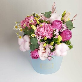 Цветы в голубой коробке с яркими розовыми цветами и хлопком