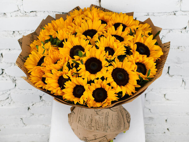 Букет 27 подсолнухов с зеленью в крафте, артикул F1159121 - 14699 рублей, доставка по городу. Flawery - доставка цветов